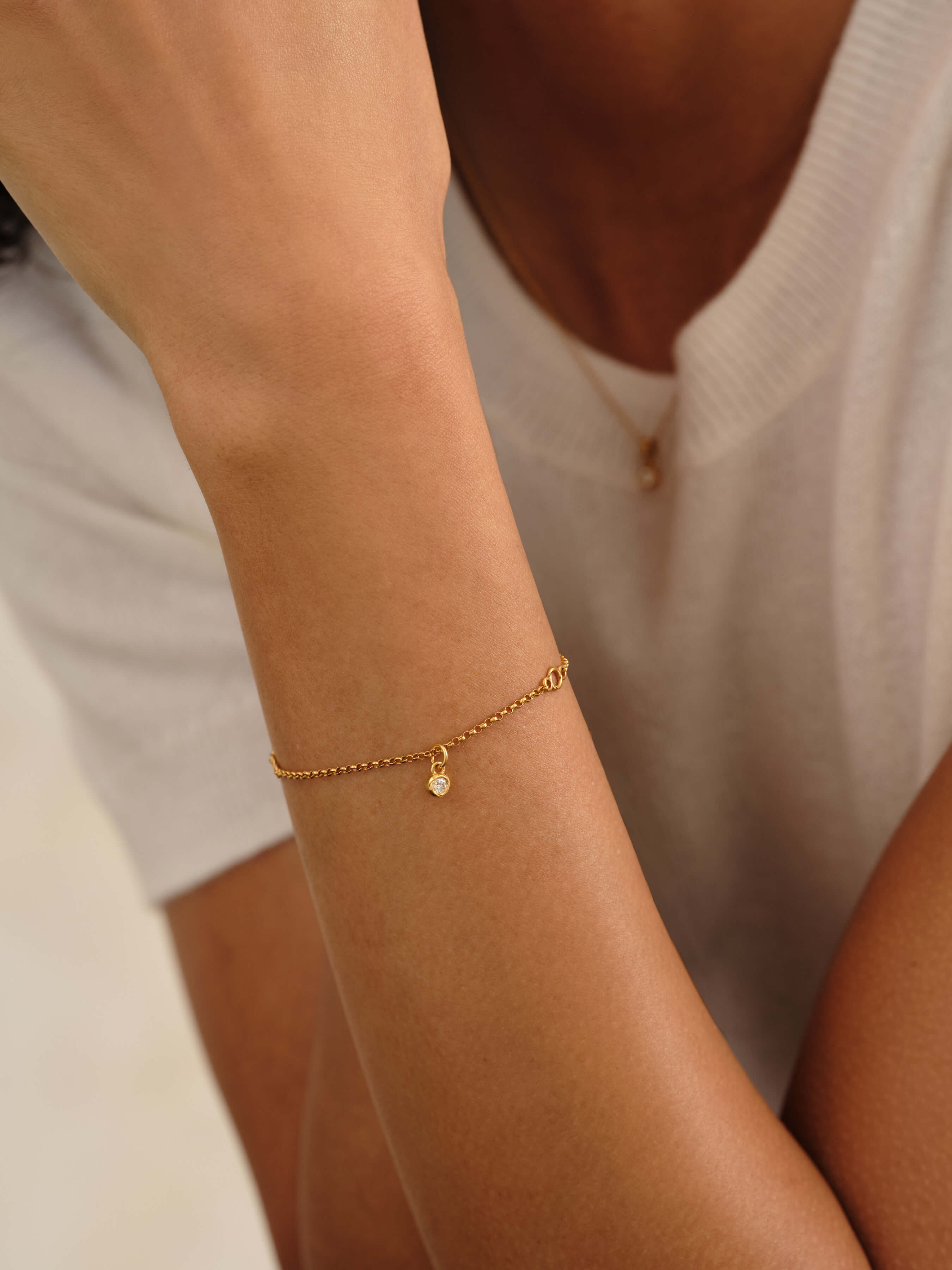 Woman wearing the Eternal Grace 14k gold vermeil lab grown diamond bracelet by MILLSÉ with a floating lab grown diamond pendant on an Italian-made chain.