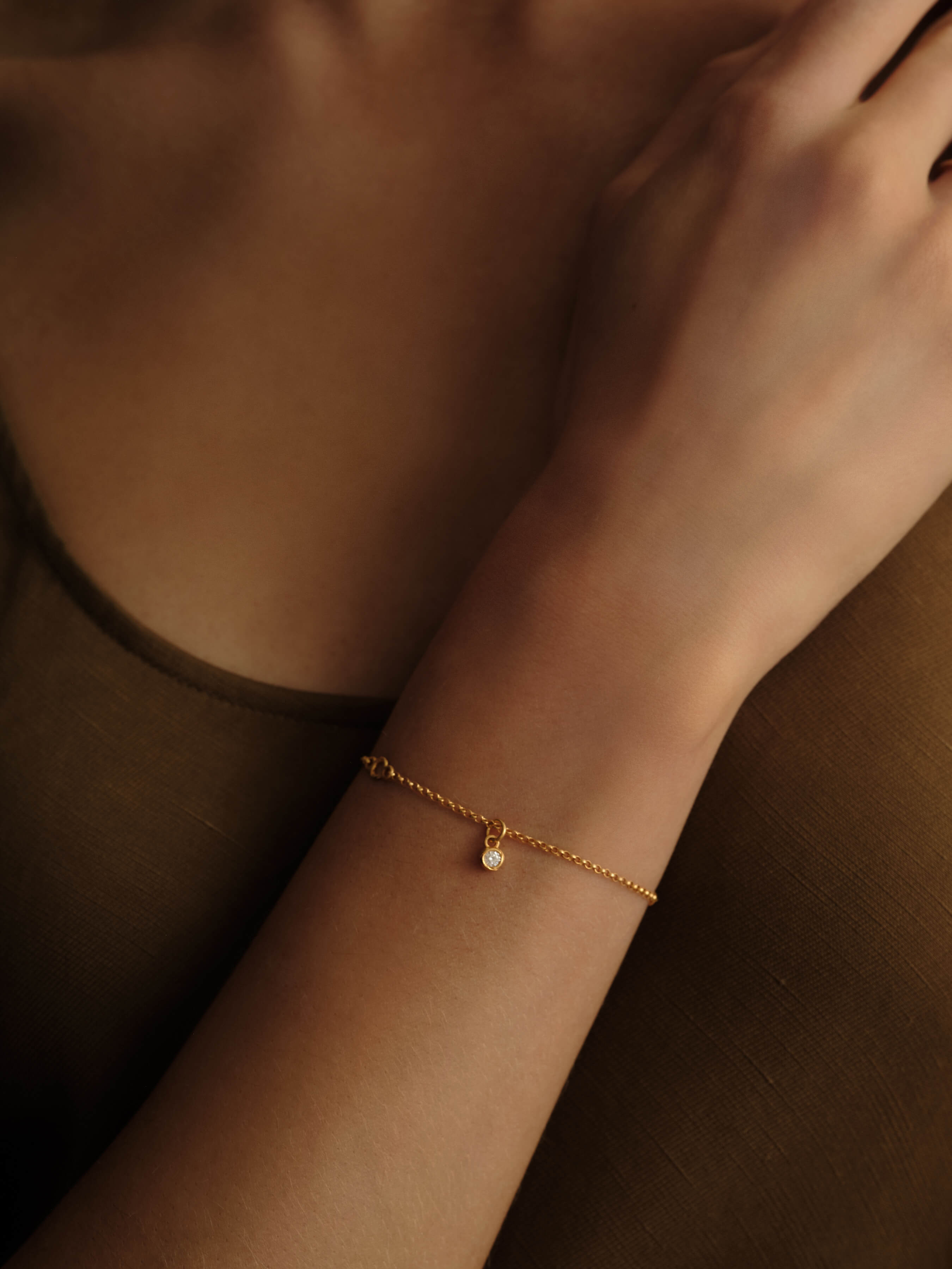 Woman wearing the Eternal Grace 14k gold vermeil lab grown diamond bracelet by MILLSÉ featuring a floating solitaire diamond pendant.