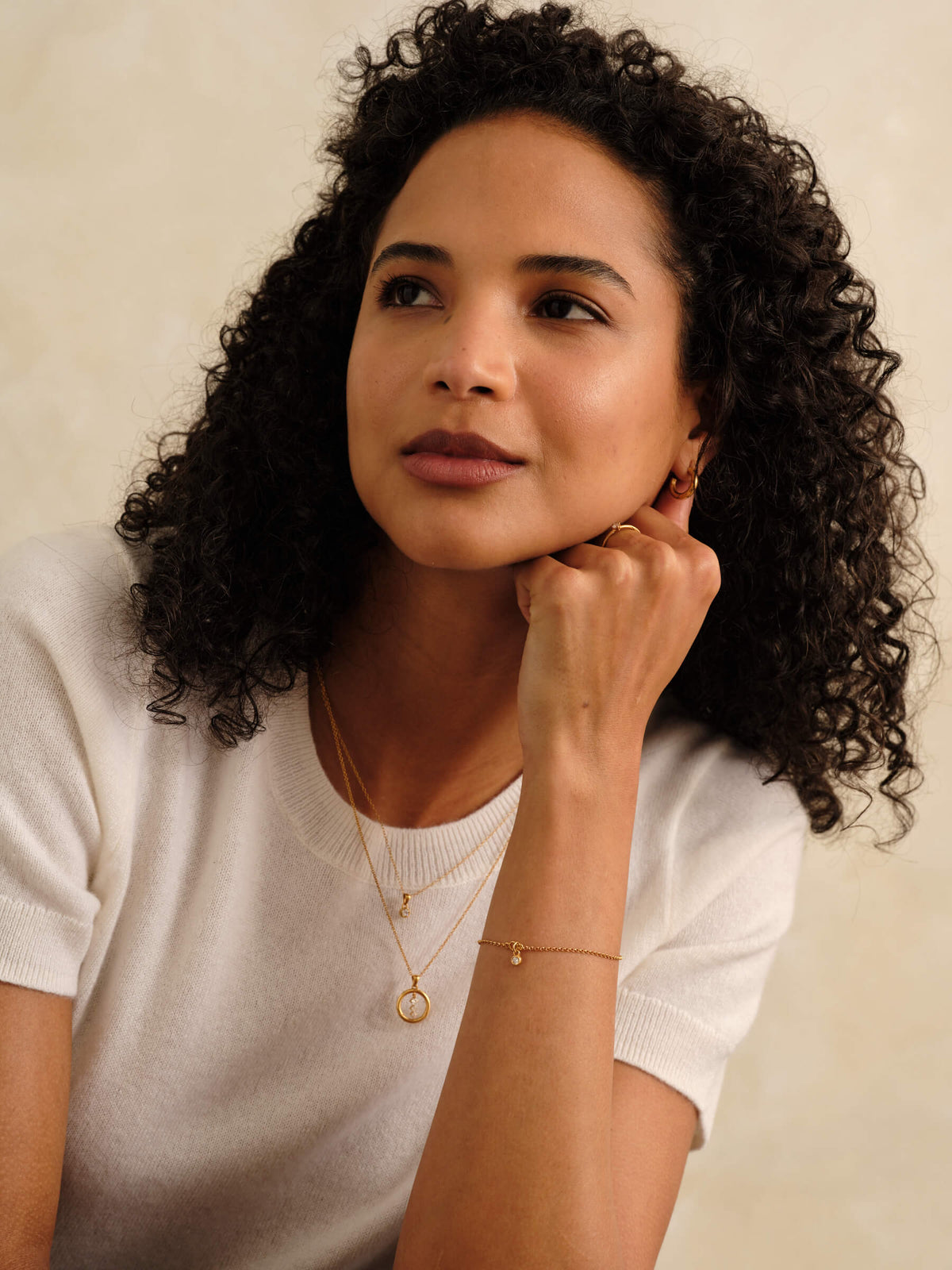 Woman wearing layered pieces from the MILLSÉ Eternal Grace 14k gold vermeil lab grown diamond jewelry collection.
